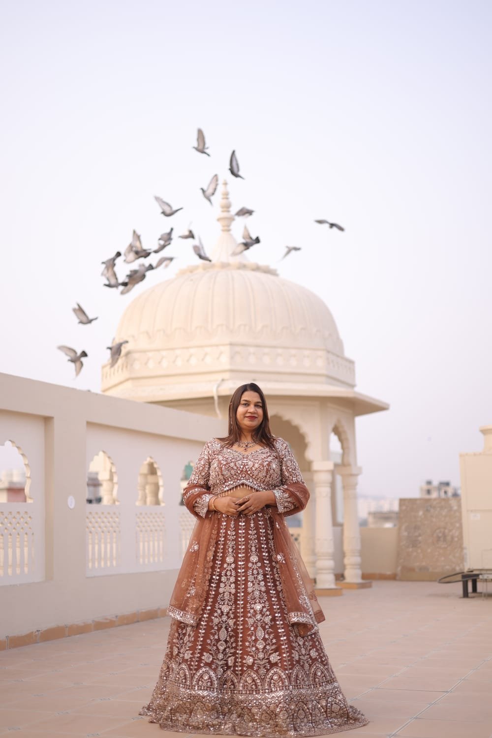 Neelam Roy in royal heritage embroidered lehenga at Rajasthani rooftop with pigeons