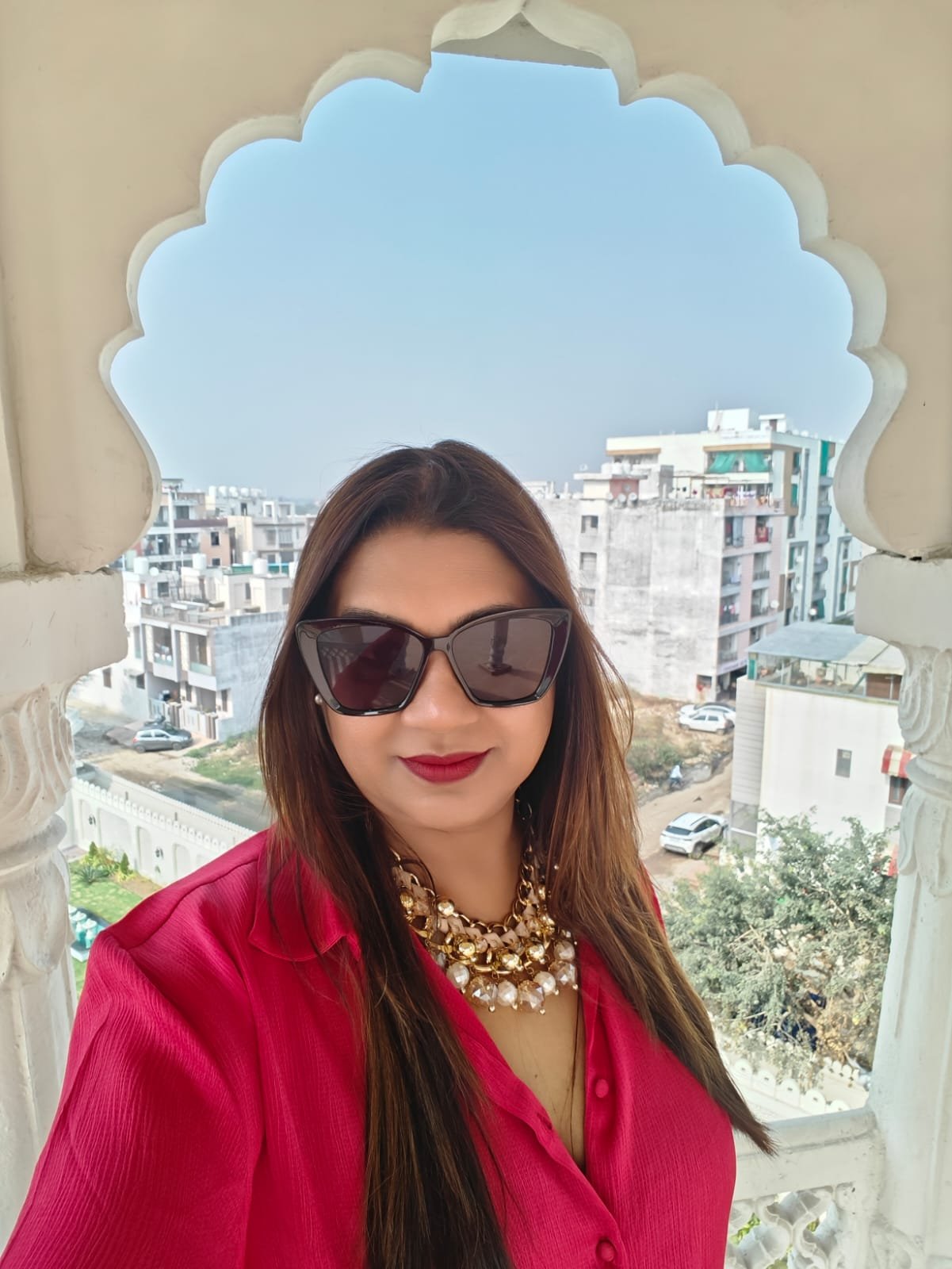 Neelam Roy at Rajasthani heritage arch window with city panorama